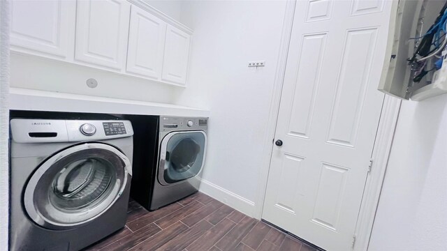 clothes washing area featuring dark hardwood / wood-style floors, washing machine and clothes dryer, and cabinets