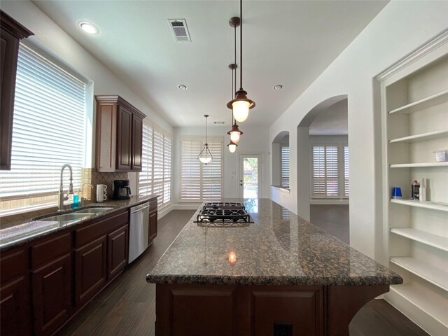 kitchen featuring a kitchen island, dark hardwood / wood-style floors, decorative light fixtures, appliances with stainless steel finishes, and sink