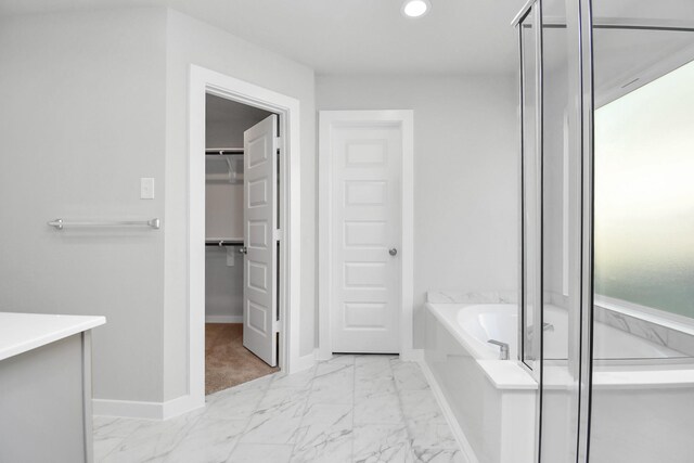 19722 Vino Vale Dr, Hockley, TX 77447 - bathroom featuring marble look tiles, a bath, baseboards, a walk in closet, and recessed lighting