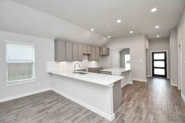 19722 Vino Vale Dr, Hockley, TX 77447 - kitchen featuring gray cabinetry, a sink, light wood finished floors, a peninsula, and light countertops