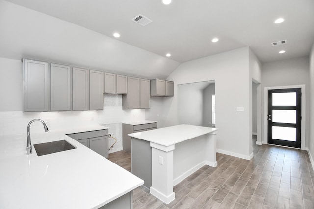 19722 Vino Vale Dr, Hockley, TX 77447 - kitchen with a sink, gray cabinets, a center island, recessed lighting, and vaulted ceiling