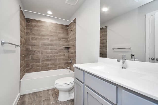 full bathroom with tiled shower / bath, toilet, hardwood / wood-style flooring, and vanity