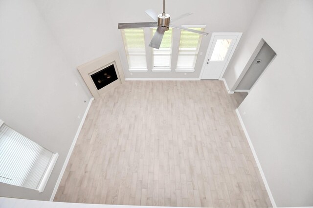 unfurnished living room featuring ceiling fan and light hardwood / wood-style floors