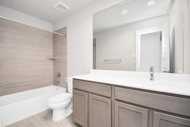 full bathroom with tiled shower / bath, toilet, and vanity