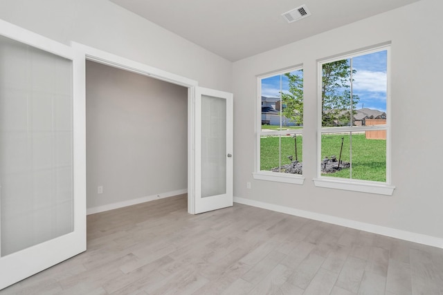 8447 Northern Pintail Dr, Houston, TX 77049 - spare room featuring french doors, light wood finished floors, and baseboards