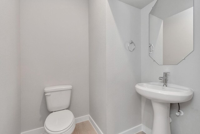8447 Northern Pintail Dr, Houston, TX 77049 - bathroom with baseboards, toilet, and wood finished floors