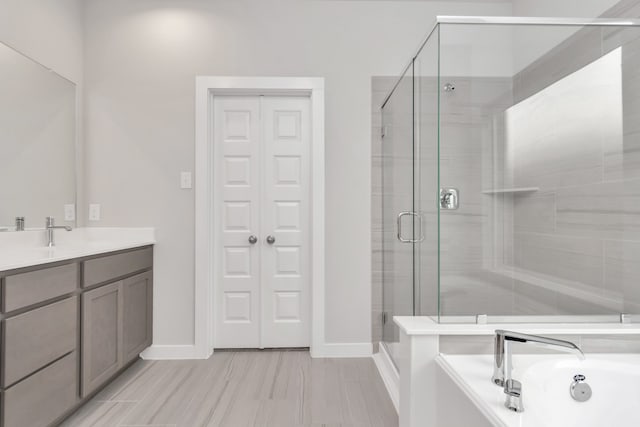 bathroom featuring shower with separate bathtub and vanity