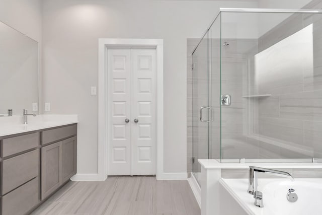 8447 Northern Pintail Dr, Houston, TX 77049 - bathroom featuring a stall shower, baseboards, vanity, and a bathtub