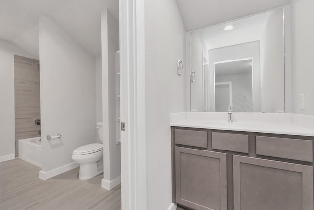 8447 Northern Pintail Dr, Houston, TX 77049 - bathroom featuring toilet, wood finished floors, vanity, baseboards, and lofted ceiling
