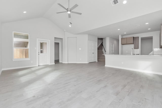 8447 Northern Pintail Dr, Houston, TX 77049 - unfurnished living room featuring stairs, ceiling fan, lofted ceiling, a sink, and baseboards