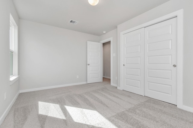 unfurnished bedroom featuring a closet and light carpet