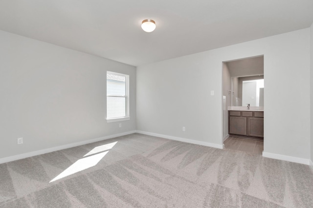 8447 Northern Pintail Dr, Houston, TX 77049 - spare room featuring light carpet, baseboards, and a sink
