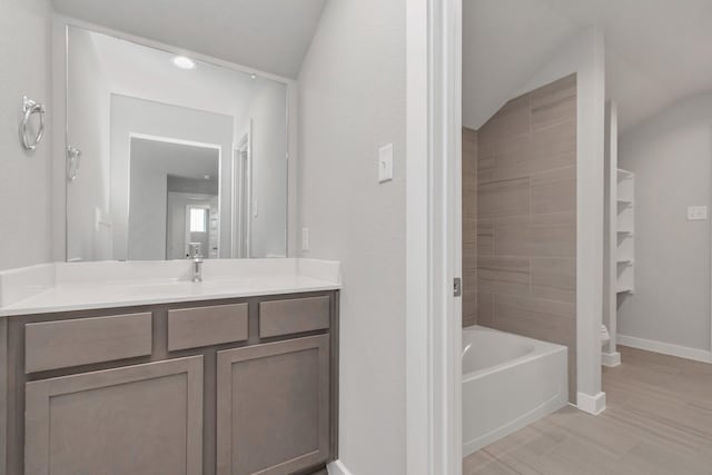 8447 Northern Pintail Dr, Houston, TX 77049 - bathroom featuring vanity, baseboards, a bath, toilet, and vaulted ceiling