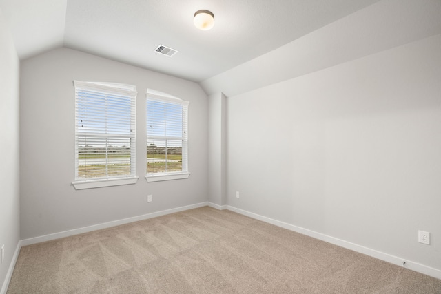 empty room featuring lofted ceiling and light carpet