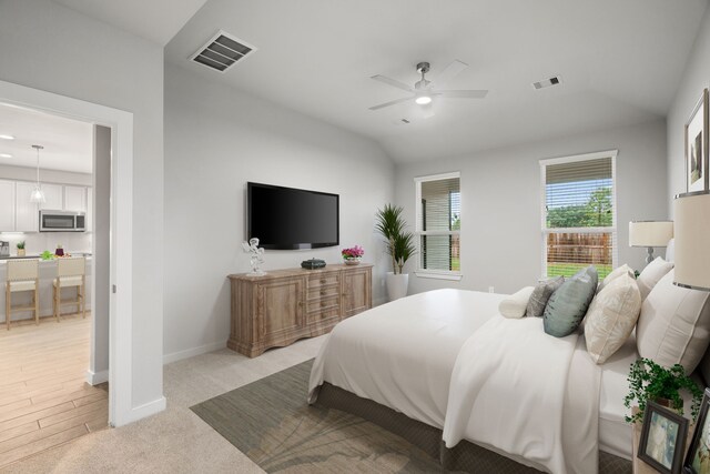 bedroom with light hardwood / wood-style flooring, ceiling fan, and vaulted ceiling