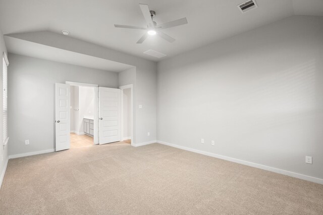 unfurnished bedroom with lofted ceiling, light colored carpet, ceiling fan, and ensuite bathroom