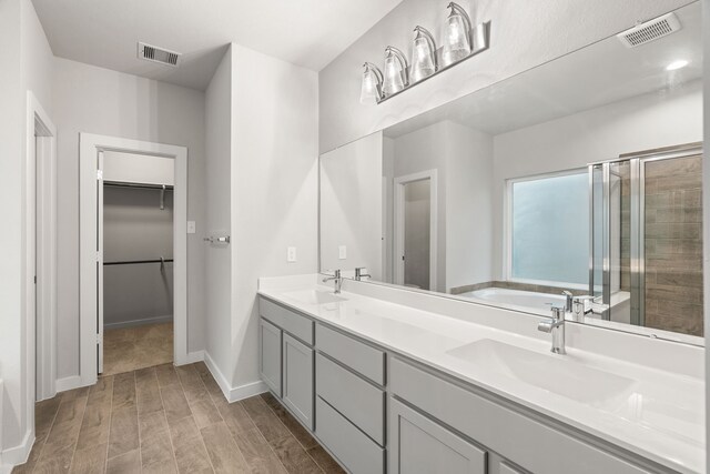 bathroom featuring vanity, separate shower and tub, and wood-type flooring