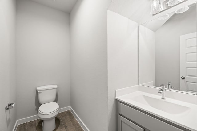 bathroom featuring vanity, toilet, and hardwood / wood-style floors