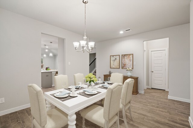 dining room featuring wood-type flooring and a chandelier