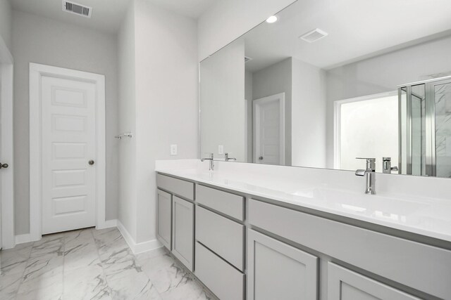 bathroom featuring a shower with door and vanity