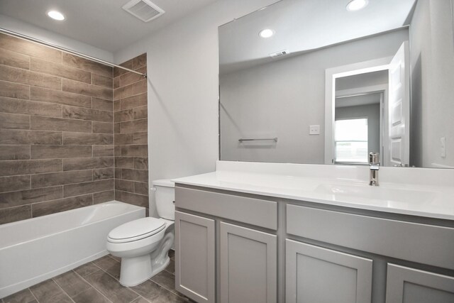 full bathroom with tiled shower / bath, toilet, and vanity