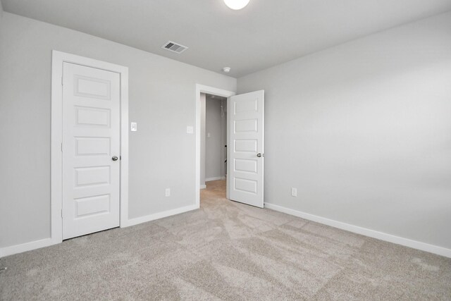 unfurnished bedroom featuring light carpet