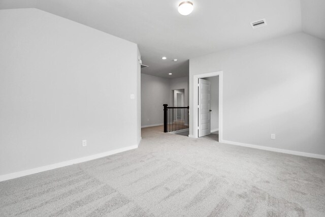 carpeted spare room featuring lofted ceiling