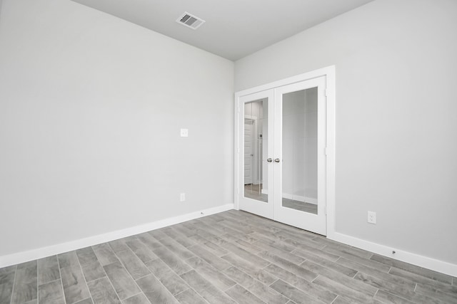 unfurnished room with french doors and light hardwood / wood-style floors