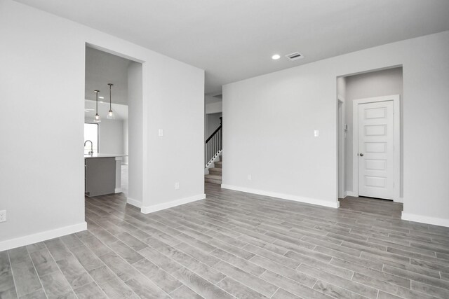 unfurnished room with light hardwood / wood-style flooring and sink