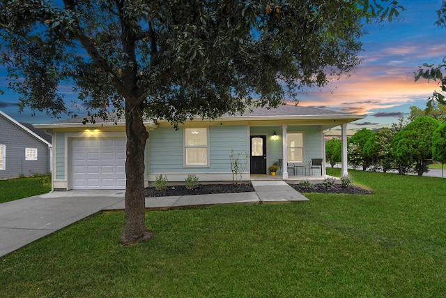 view of front of home featuring covered porch, a yard, and a garage