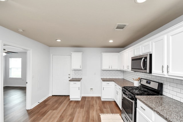 kitchen featuring light wood-type flooring, white cabinetry, stainless steel appliances, and ceiling fan