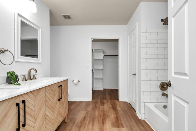 bathroom featuring vanity, hardwood / wood-style flooring, and shower / bathtub combination