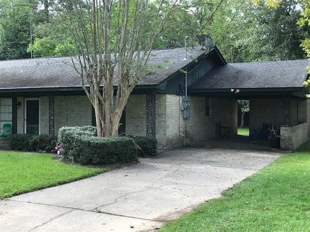1702-1704 Southline St Unit 170, Cleveland, TX 77327 - view of side of home featuring driveway, a lawn, an attached carport, and brick siding