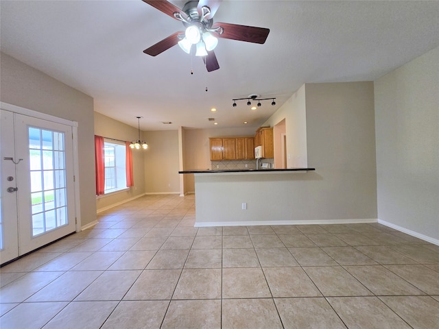 unfurnished living room with light tile patterned floors and ceiling fan with notable chandelier