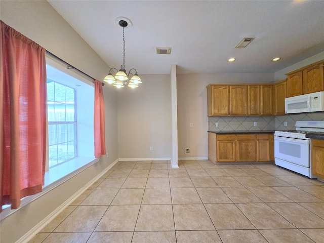 kitchen with decorative backsplash, hanging light fixtures, a notable chandelier, light tile patterned floors, and white appliances