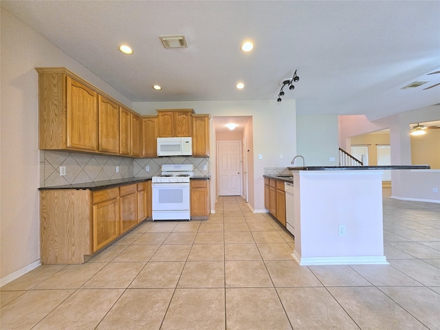 kitchen featuring white appliances, backsplash, light tile patterned flooring, and sink