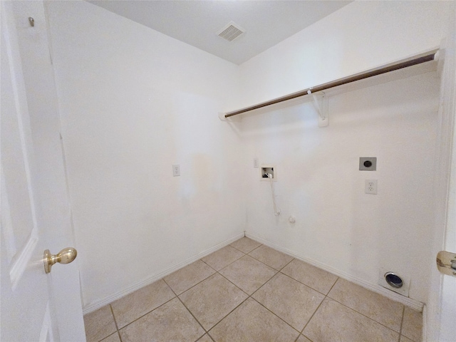 clothes washing area featuring gas dryer hookup, hookup for an electric dryer, hookup for a washing machine, and light tile patterned floors