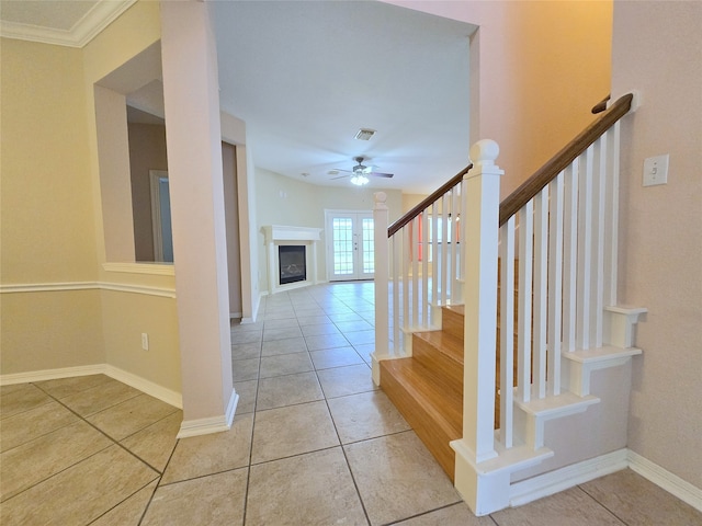 staircase with ornamental molding, tile patterned floors, and ceiling fan