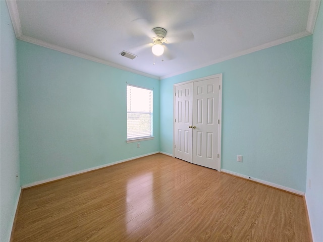 empty room featuring light hardwood / wood-style floors, ornamental molding, and ceiling fan