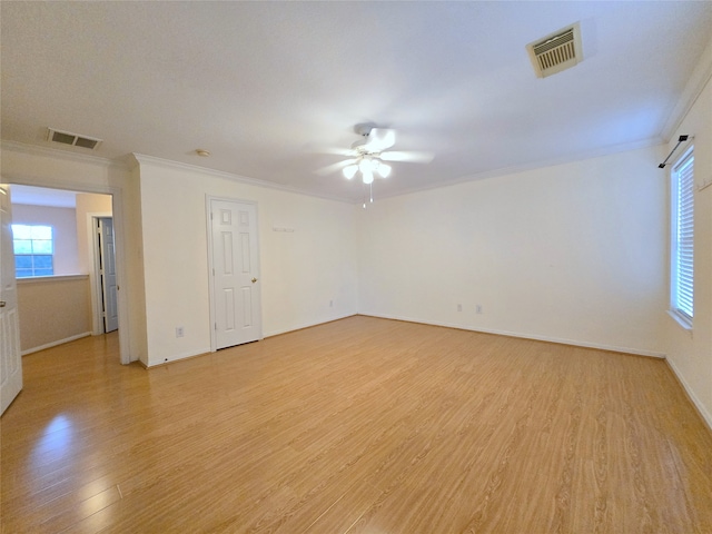 spare room featuring ceiling fan, crown molding, and light wood-type flooring