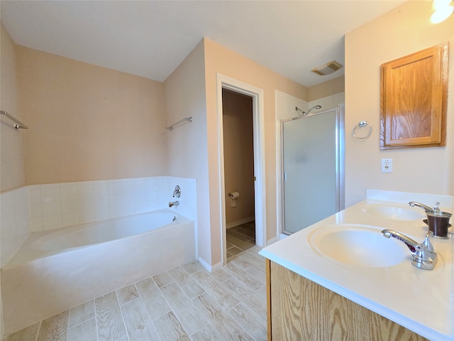 bathroom featuring vanity, hardwood / wood-style flooring, and plus walk in shower