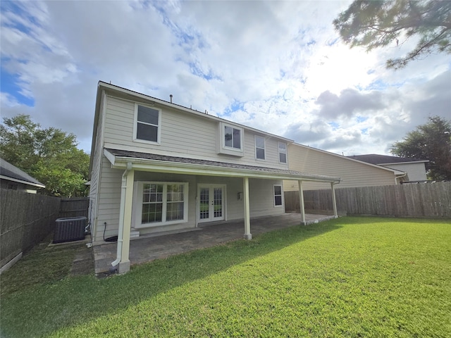 rear view of property with central air condition unit, a patio area, and a yard