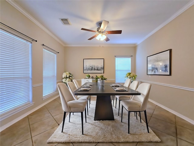 dining area with crown molding, light tile patterned flooring, and ceiling fan