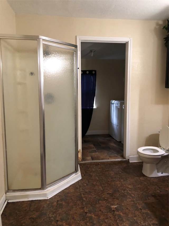 bathroom with a shower with shower door and toilet