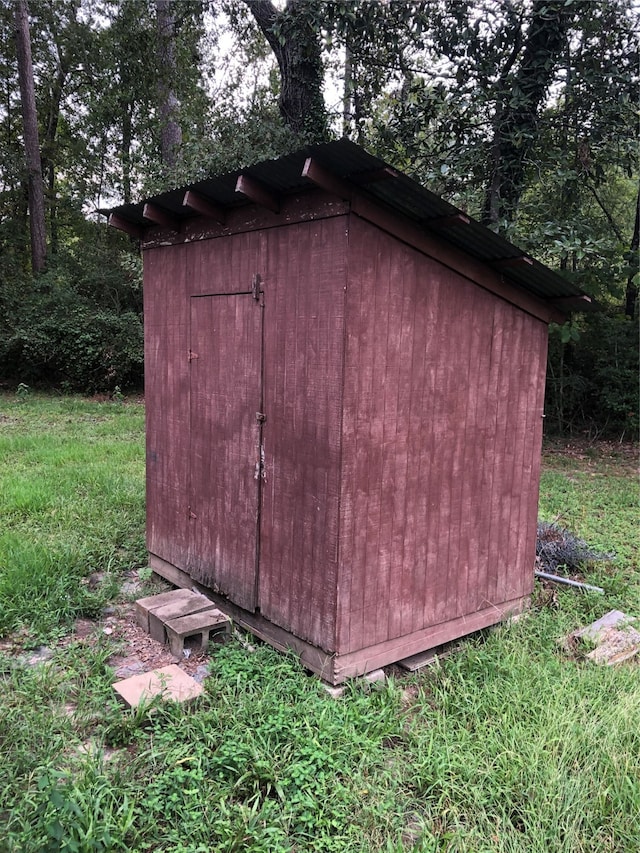 view of outdoor structure featuring a lawn