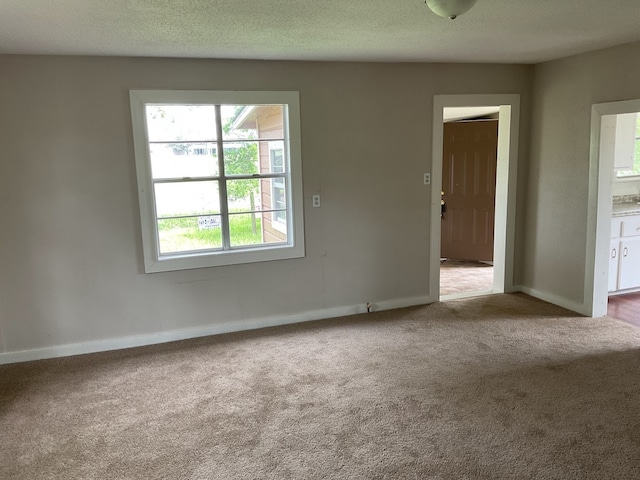 carpeted spare room featuring a textured ceiling