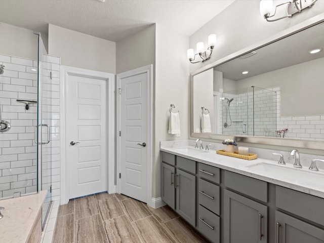 bathroom featuring vanity, a textured ceiling, and a shower with door