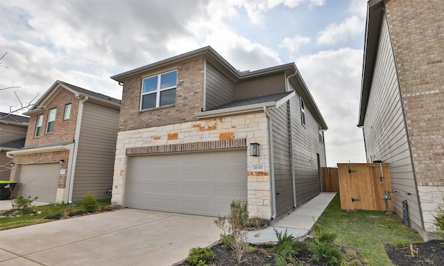 view of front facade featuring concrete driveway, an attached garage, and stone siding