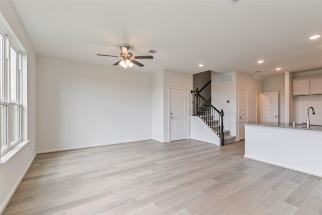 unfurnished living room featuring recessed lighting, stairway, light wood-style flooring, and visible vents