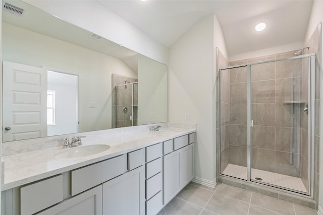 full bathroom with tile patterned flooring, visible vents, a shower stall, double vanity, and a sink